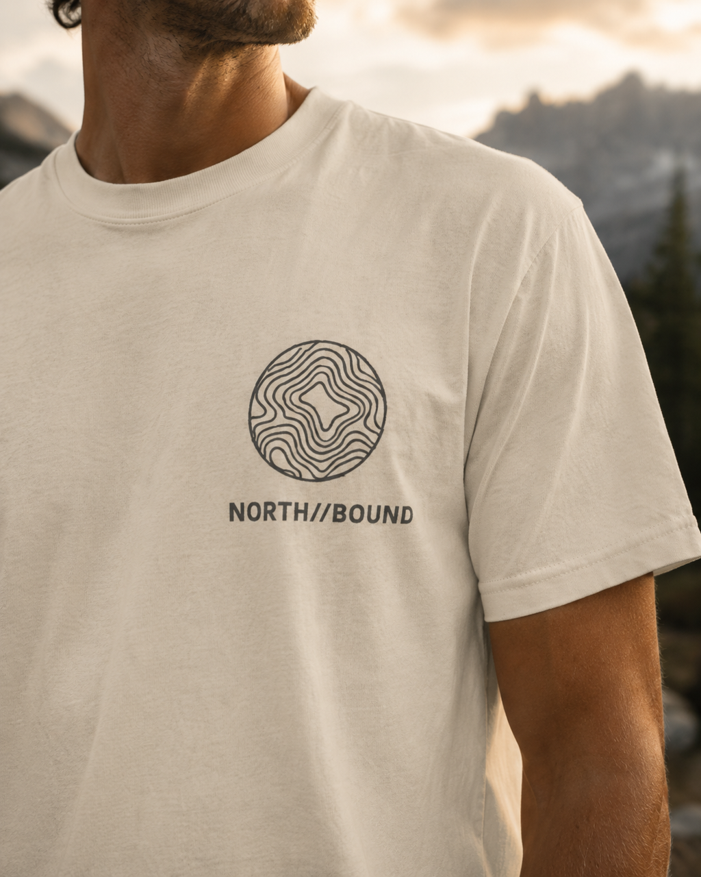 Close-up of NORTH//BOUND chest logo on sand heavyweight t-shirt